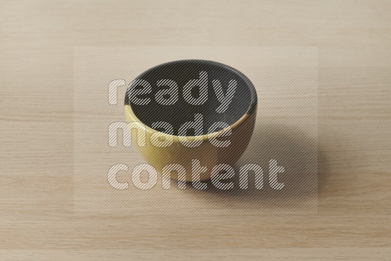 A multicolored pottery bowl on light wooden background