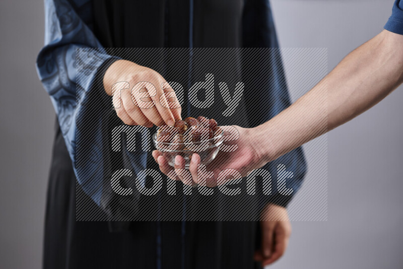 Woman in abaya holding dates in different positions