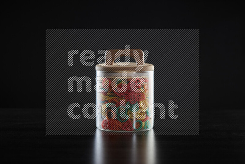 Snacks in a glass jar on black background