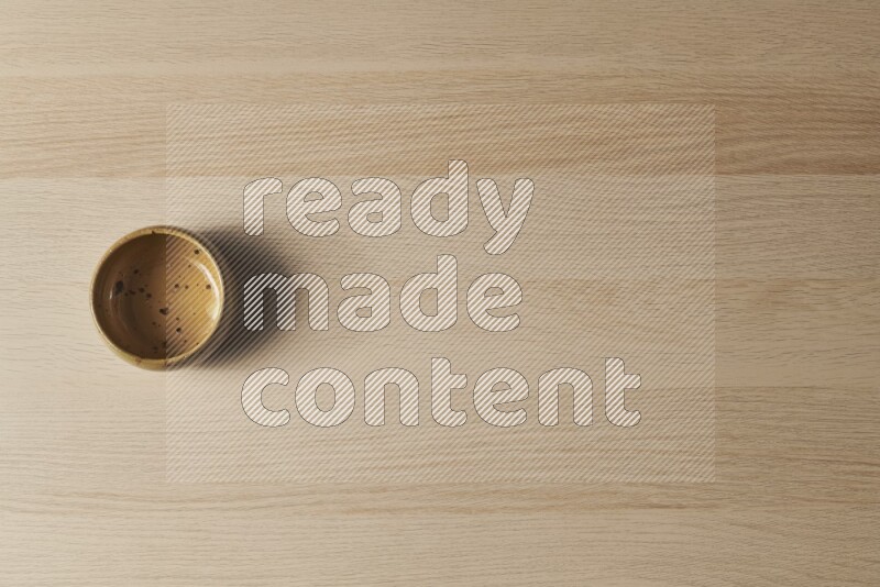 وعاء فخاري متعدد الألوان على خلفية خشبية فاتحة