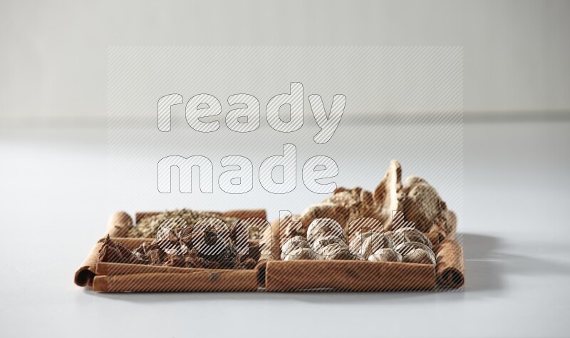4 squares of cinnamon sticks full of star anise, ginger, cumin and nutmeg on white flooring