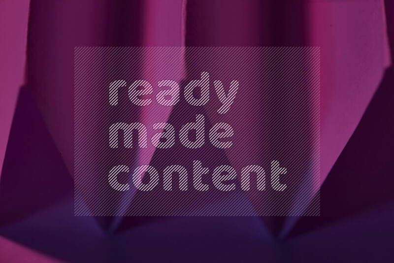 A close-up abstract image showing sharp geometric paper folds in purple gradients