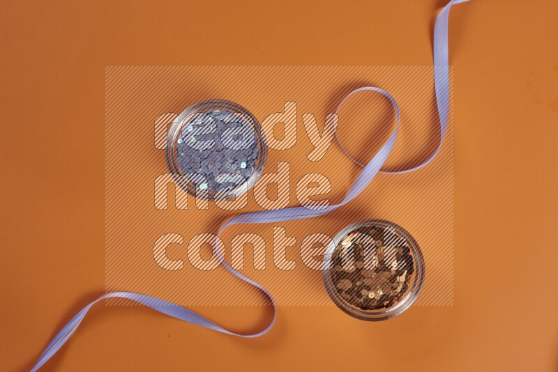 A purple collection of sewing and tailoring tools arranged on a orange background