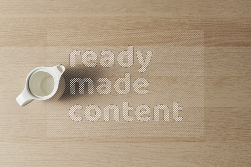 A ceramic milk jug on light wooden background