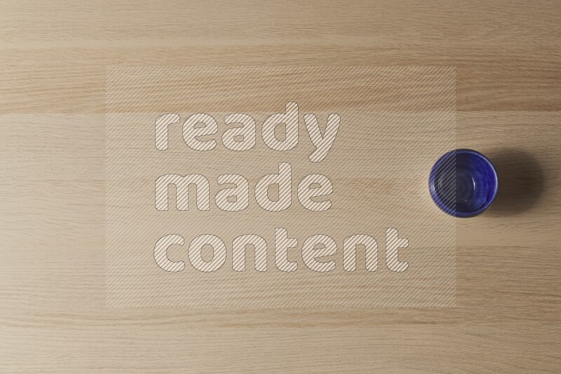 A pottery cup on light wooden background