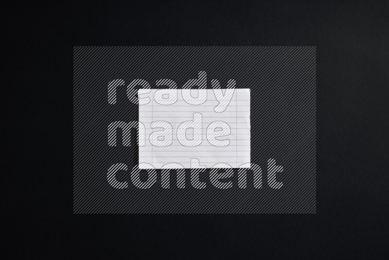 Folded notebook sheet on black background