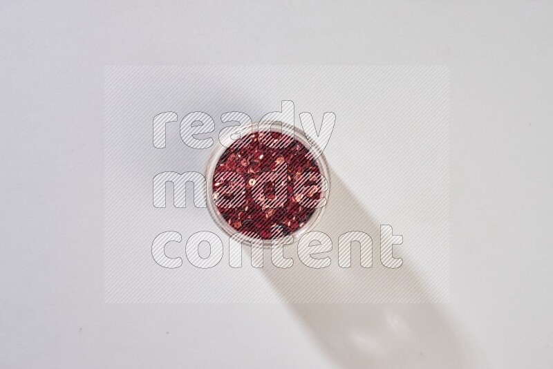 ترتر ملون في وعاء زجاجي على خلفية رمادية