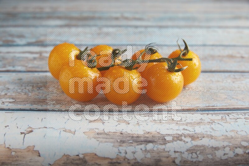 yellow cherry tomato vein on a textured blue wooden background 45 degree