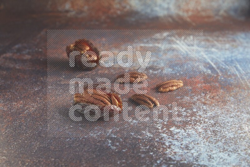 two pecan stuffed madjoul dates on a rustic reddish background