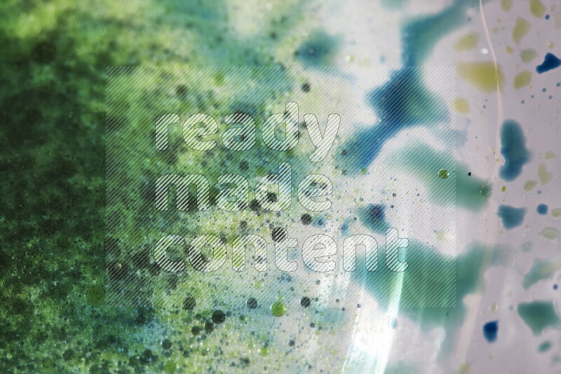 Close-ups of abstract green and blue watercolor drops on oil Surface on white background