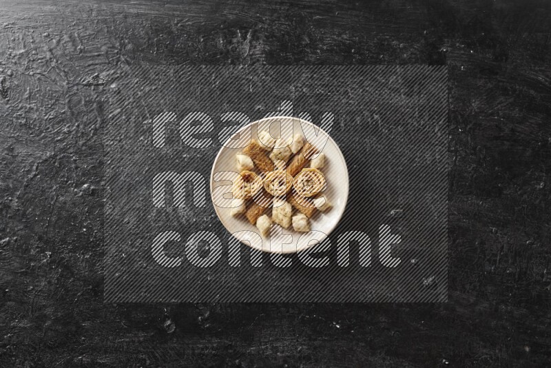 حلويات شرقية في أطباق فخارية علي خلفية سوداء خشبية