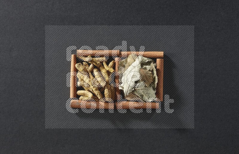 2 squares of cinnamon sticks full of bay laurel leaves and turmeric fingers on black flooring