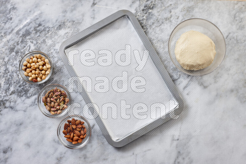 Ghoriba step by step with its ingredient, flour, powdered sugar, ghee and nuts on grey marble background