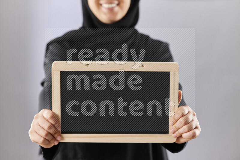 A woman in abaya holding books and a board in different positions (back to school)