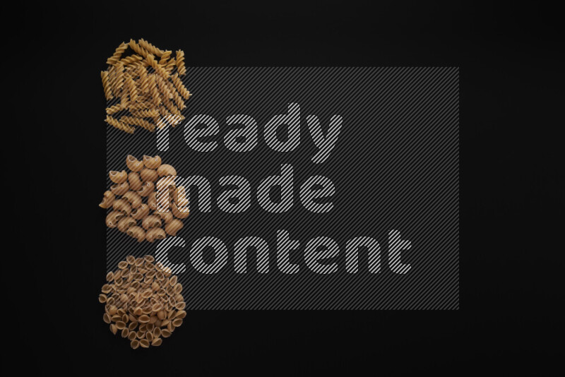 Different pasta types in 3 bunches on black background