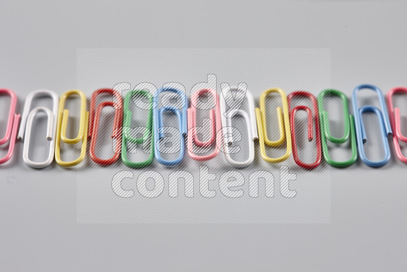 Multicolored paper clips isolated on a grey background