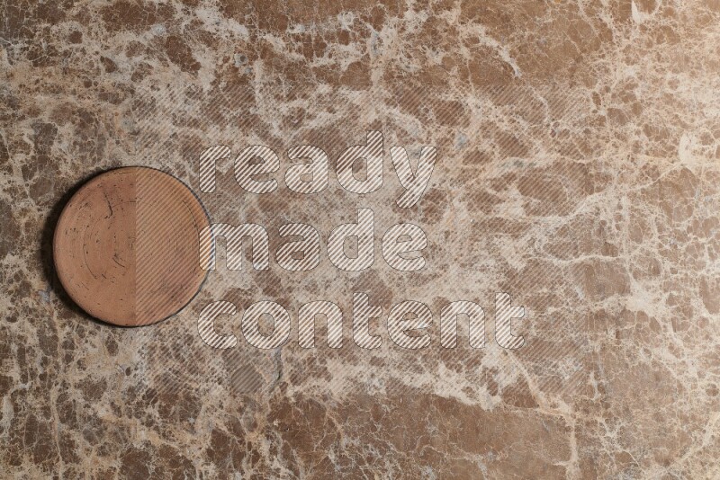 A pottery coaster on beige marble background