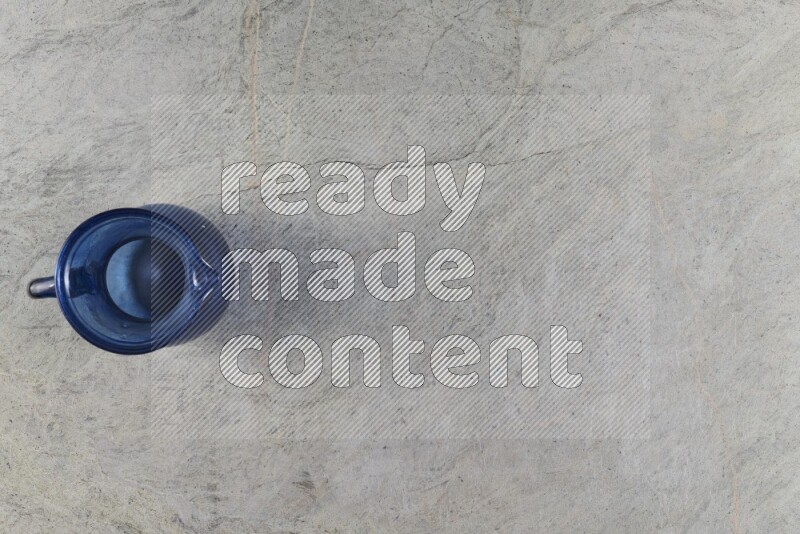 إبريق زجاجي فارغ على خلفية من الرخام الرمادي