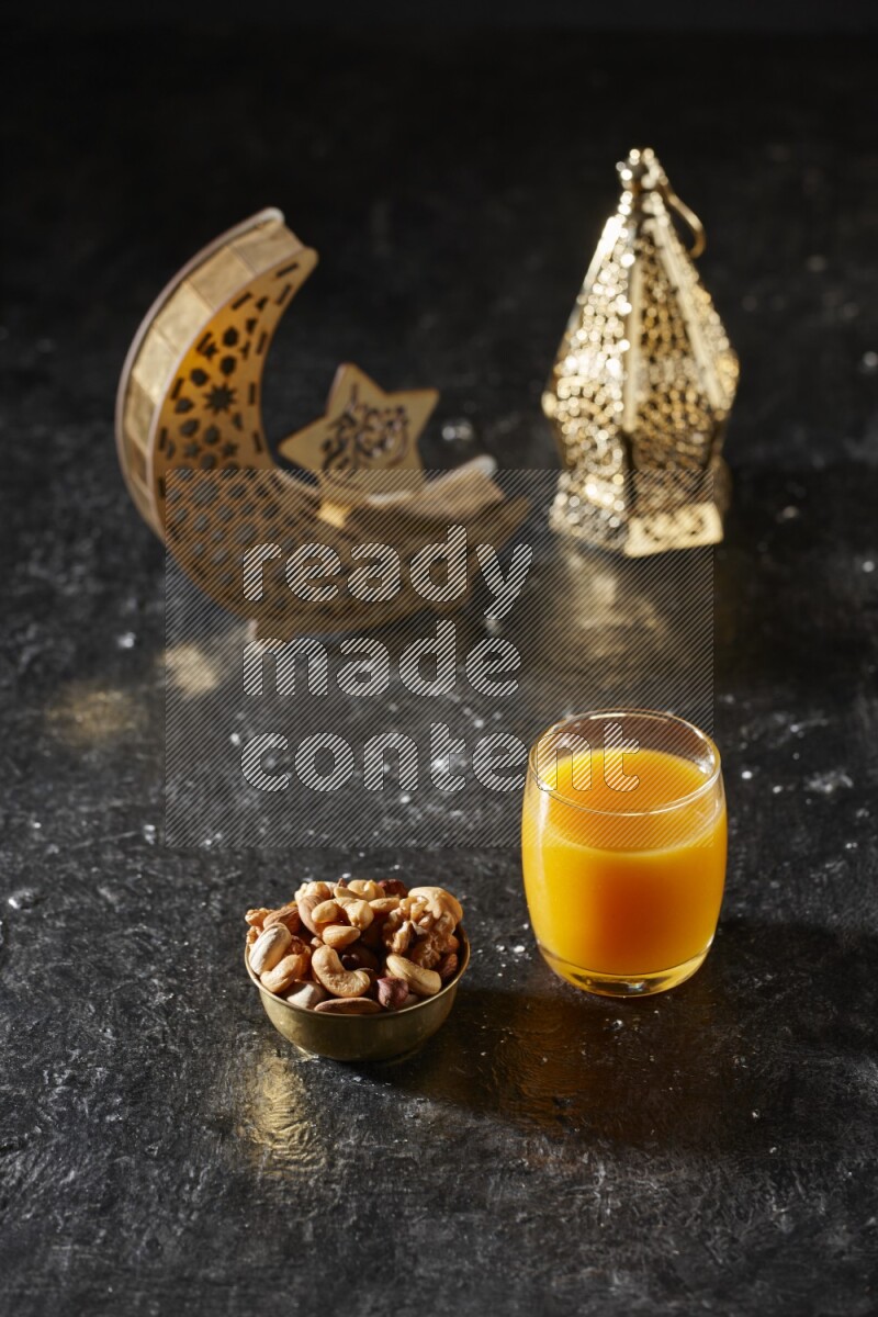 مكسرات في وعاء معدني مع مشروب قمر الدين بجانب فوانيس ذهبية علي خلفية سوداء