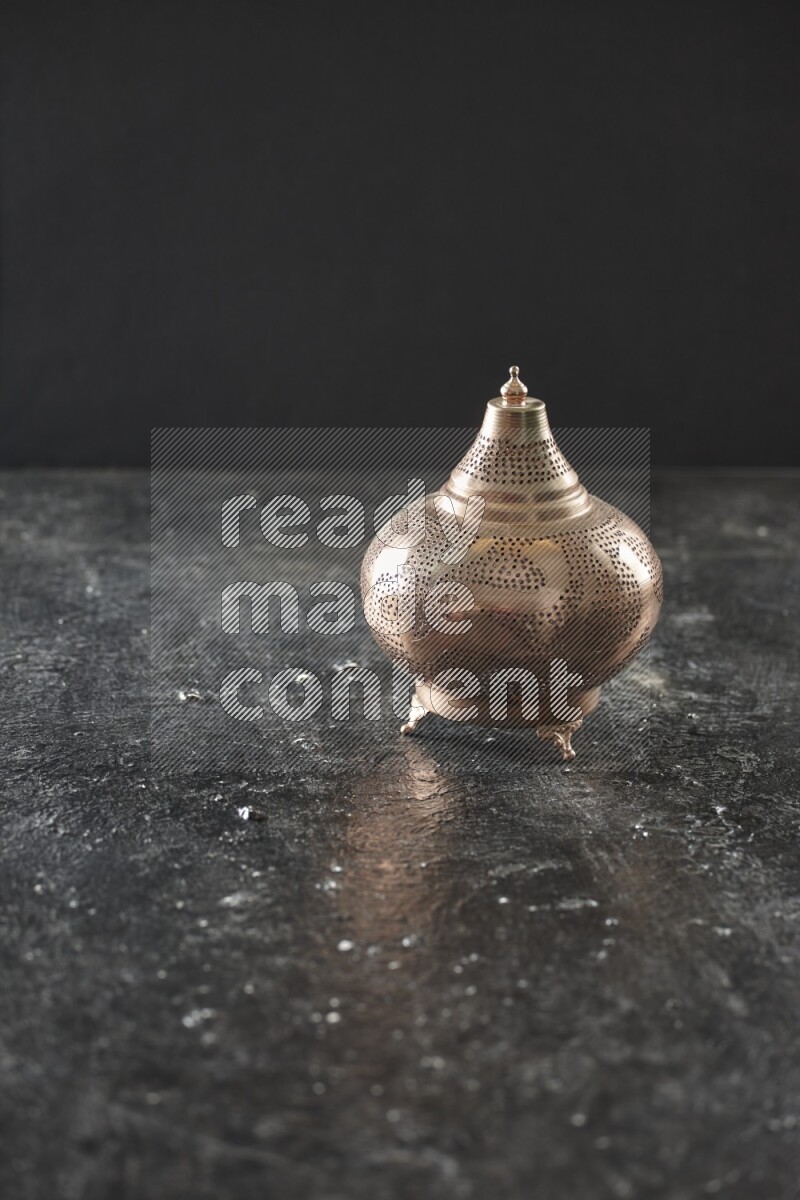 A lantern placed on a textured black background