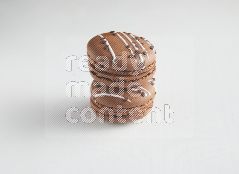 45º Shot of two Brown white Chocolate Caramel macarons on white background