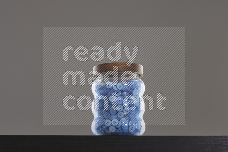 Buttons in a glass jar on black background