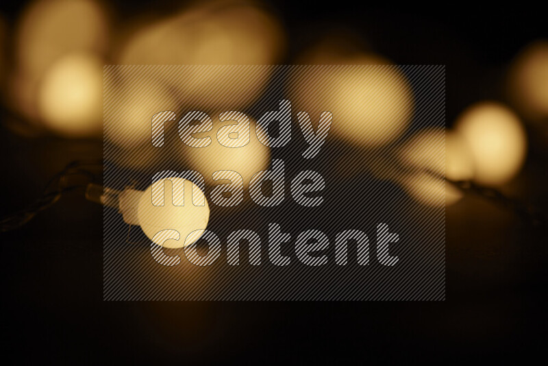 Light bulbs glowing against backdrop of golden bokeh