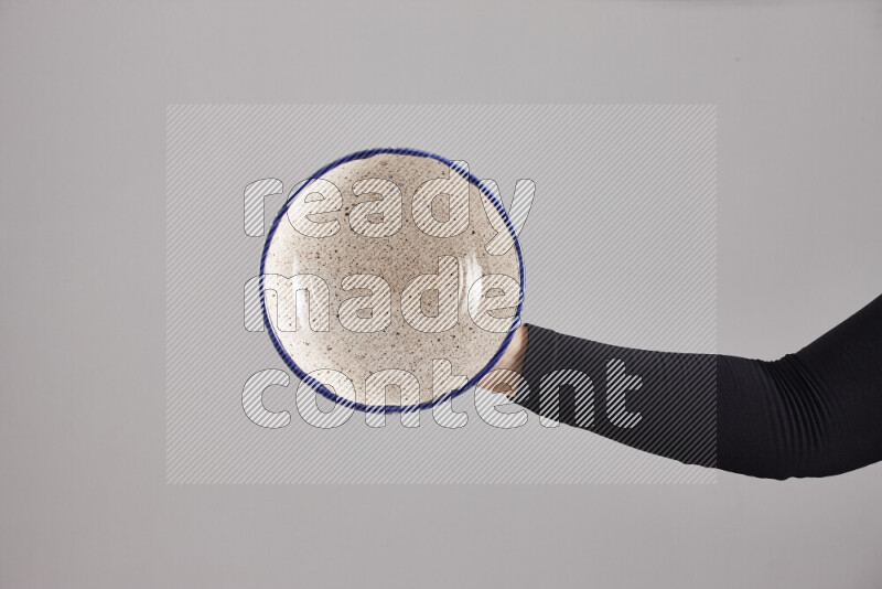 A woman in black abaya holding different pottery essentials in different positions