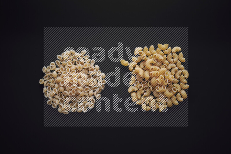 Different pasta types in bunches on black background