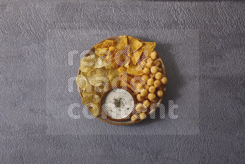 Assorted snacks in pottery bowls on grey background