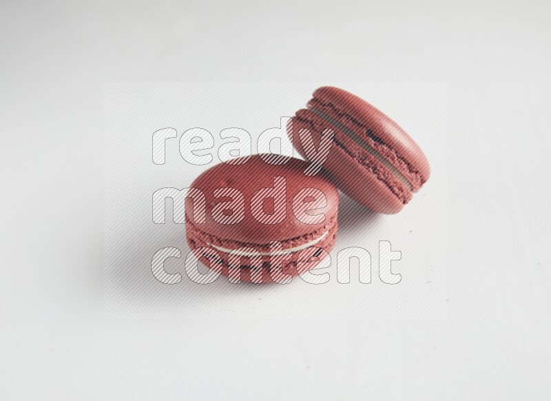 45º Shot of two Red Velvet macarons on white background