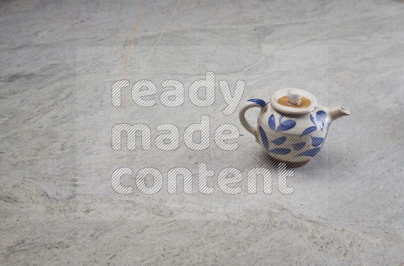 A pottery teapot on grey marble background