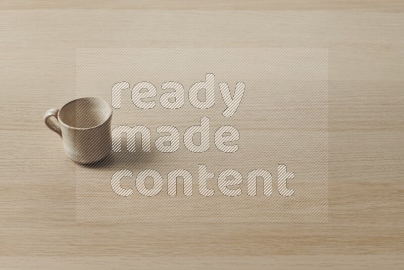 كأس فخاري على خلفية خشبية فاتحة