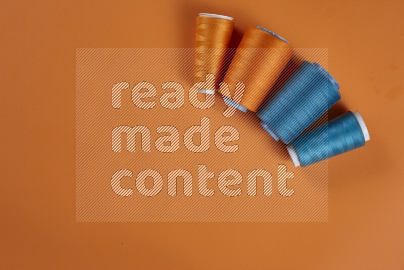A blue collection of sewing and tailoring tools arranged on a orange background