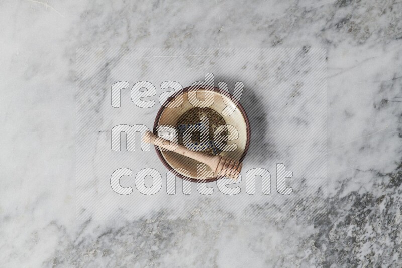 Decorative pottery plate with wooden honey dipper in it on grey marble background