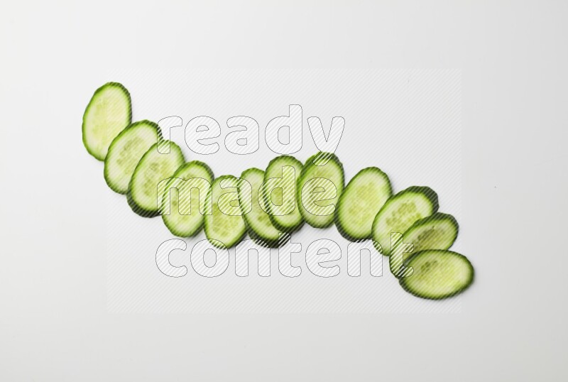 Multiple cucumber slices on white background
