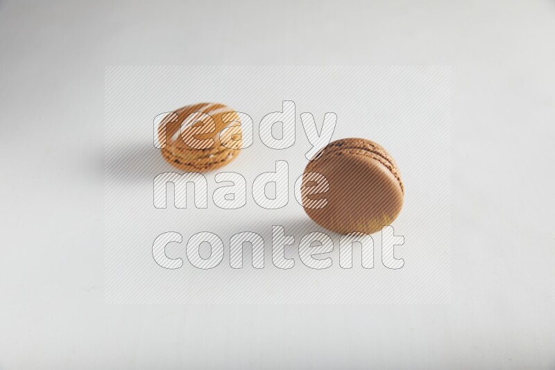 45º Shot of of two assorted Brown Irish Cream, and Brown Coffee macarons  on white background