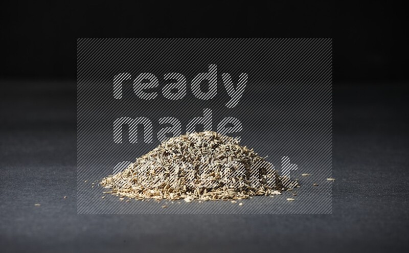 Cumin seeds on black flooring