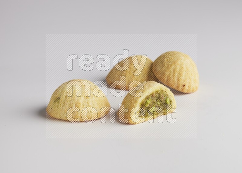 Four Pieces of Maamoul filled with pistachio  paste one of them is cut direct on white background