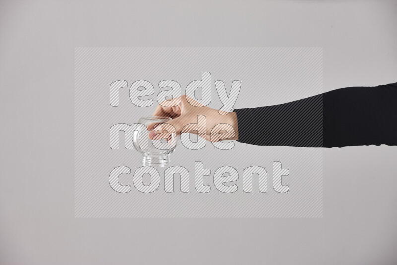 امرأة ترتدي عباءة سوداء تحمل أدوات زجاجية مختلفة في أوضاع متعددة