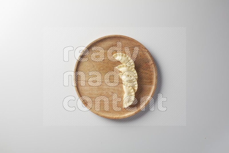 Four Sambosas on a wooden round plate on a white background