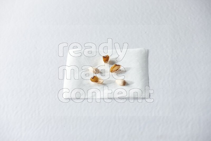 Pistachio peels on a piece of paper on a white background in different angles