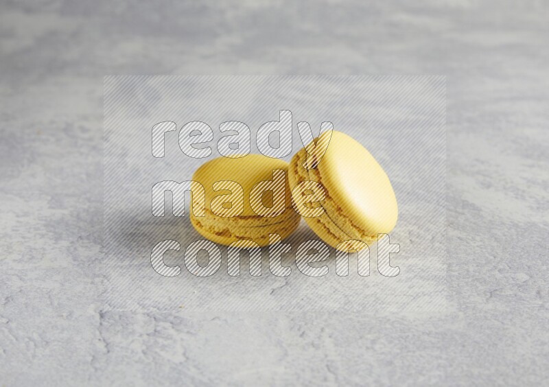 45º Shot of two Yellow Lemon macarons  on white  marble background