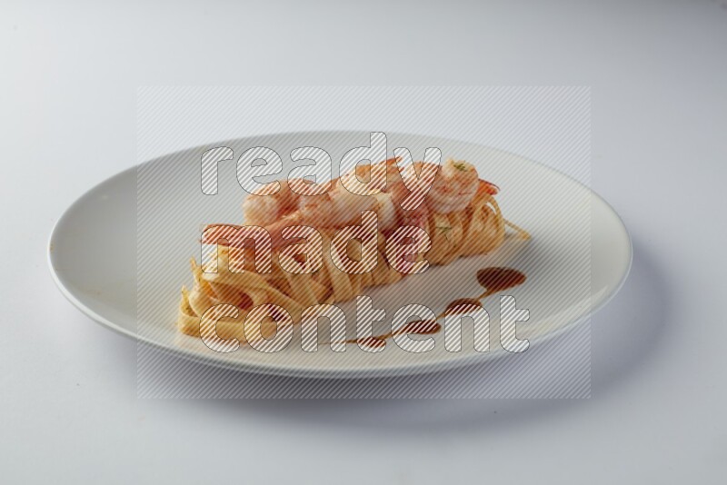 Fettuccini red sauce pasta with shrimp in a white plate on a white background