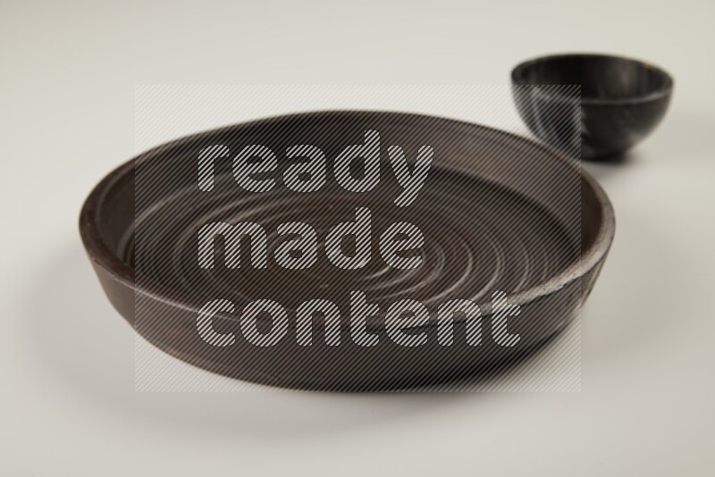 black pottery plate and black bowls on white background