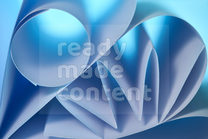 An artistic display of paper folds creating a harmonious blend of geometric shapes, highlighted by soft lighting in blue tones