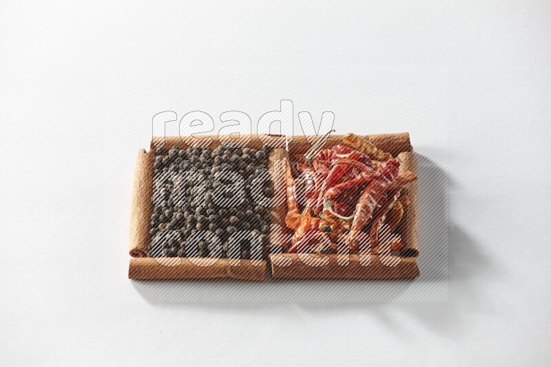 2 squares of cinnamon sticks full of red dried chilis and black pepper on white flooring