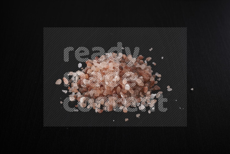 A bunch of coarse himalayan salt crystals on black background