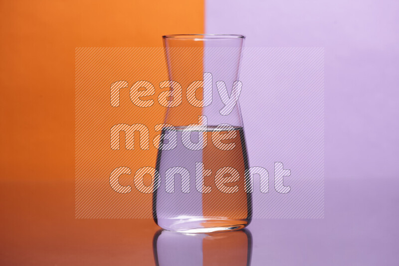 The image features a clear glassware filled with water, set against orange and light purple background