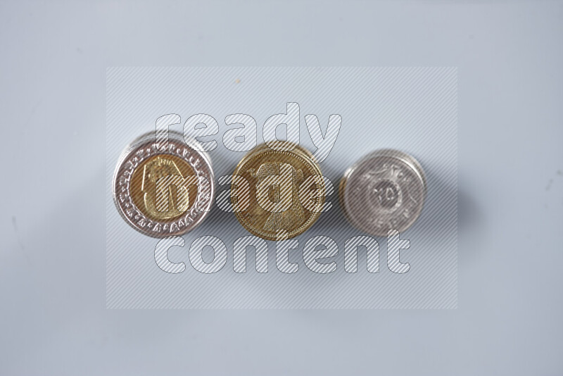 A close-up of scattered mixed Egyptian coins such as One pound, 50 and 25 piasters on grey background